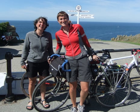 The couple with their bikes in front of a sign