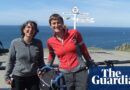 The couple with their bikes in front of a sign