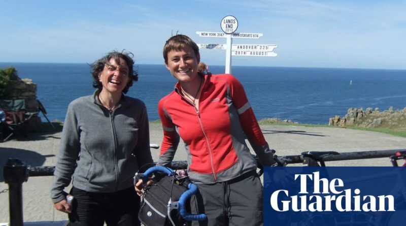 The couple with their bikes in front of a sign