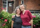 The couple with their arms around each other in a garden