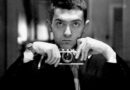 A black-and-white shot of a young Stanley Kubrick holding a camera
