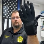 a man in uniform wears a bulky black glove