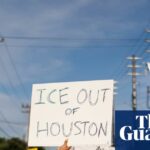 A woman holds a sign reading "ICE OUT OF HOUSTON" during a protest in July.